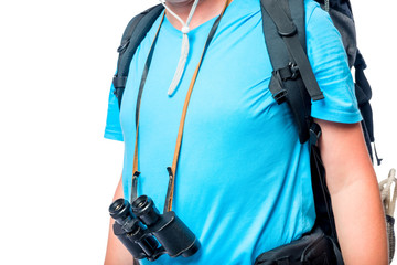 The tourist's chest with a backpack and binoculars close-up