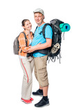 Fototapeta Las - Hugging couple of young tourists with backpacks posing on white background