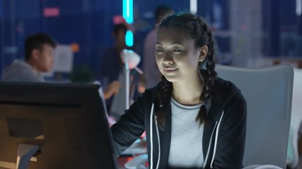  Portrait smiling computer game designer working at her desk