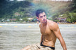 © theartofphoto - Handsome young man laying down on a beach in Phuket Island, Thailand, shirtless wearing boxer shorts, showing muscular fit body