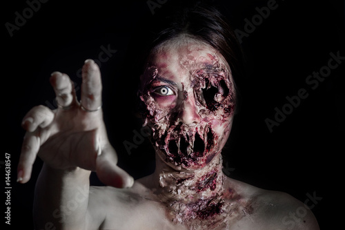 Fotografía horrible scary zombie girl on black background with copyspace