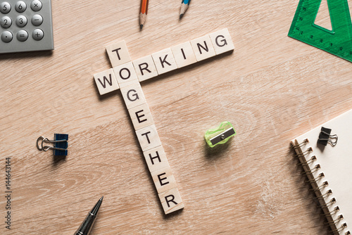 Fotografie, Obraz Working together words collected of game cubes on wooden surface