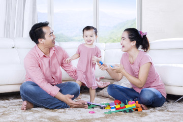 Wall Mural - Asian family enjoying leisure time with toys