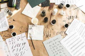 calligraphy sheets, nibs, paper, ink and pens on a kraft background. lettering calligraphy workshop.