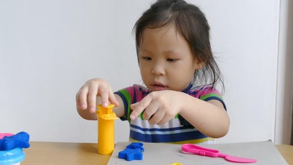 Wall Mural - little asian girl play with dough modeling clay for kids