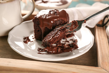 Fork with piece of cocoa brownie and cake on plate, closeup