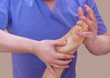 © Dimid - The doctor-podiatrist does an examination and massage of the patient's foot in the clinic.