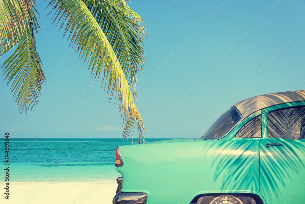 Classic car on a tropical beach with palm tree, vintage process - obrazy, fototapety, plakaty 