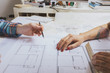 © Jorge Garcia Romeu/ADDICTIVE STOCK - From above two designers working on a plan. Horizontal indoors shot.
