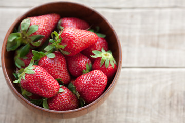 Wall Mural - Fresh strawberries in a wooden bowl on a wooden table