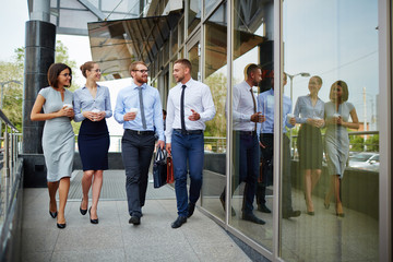 Sticker - Group of young successful business people leaving modern office building and smiling cheerfully chatting on the way