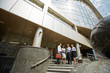 © pressmaster - Wide angle shot, group of business people standing on steps of modern office building with glass fronts and stone stairs