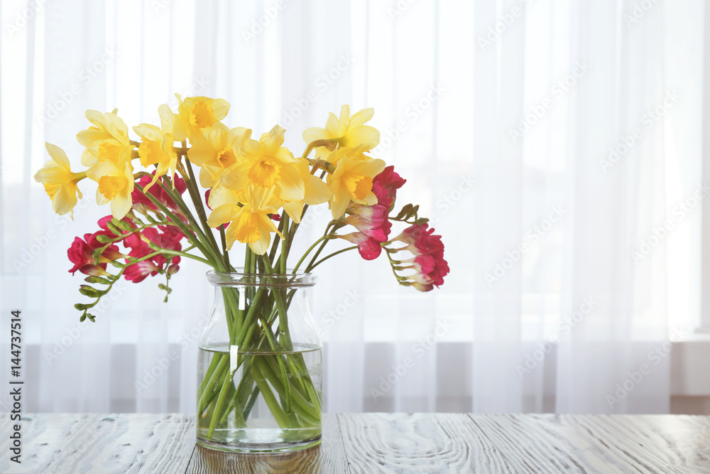 Vase with beautiful flowers on table