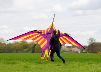 a man flies a coloured a kite