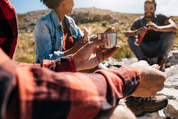 Wall Mural - young man relaxing with friends during a hike