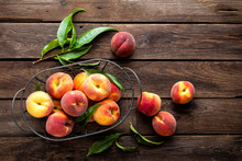 Fresh Peaches Fruits With Leaves In Basket On Dark Wooden Rustic Background, Top View