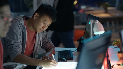  Young computer game designer drawing & working on computer