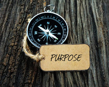 Compass And Paper Tag Written With PURPOSE On Wooden Background.