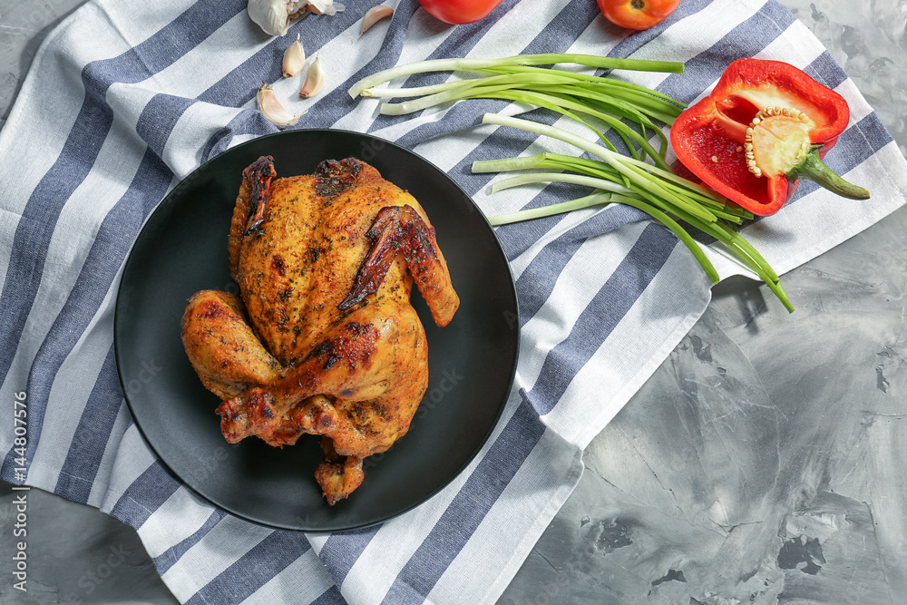 Plate with roasted beer can chicken on table