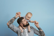 © Africa Studio - Handsome tattooed young man holding cute little baby on light background
