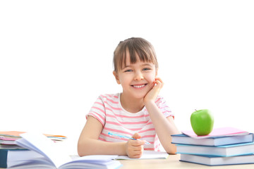 Wall Mural - Happy schoolgirl studying at table on white background