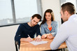 © W PRODUCTION - happy young couple in office with businessman on business buying agreement contract signature
