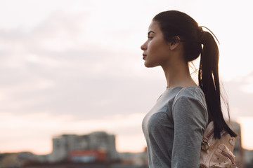 Stylish woman standing on roof and relaxing