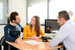 © W PRODUCTION - happy young couple in office with businessman on business buying agreement contract signature