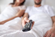 © Syda Productions - happy couple lying in bed at home and watching tv
