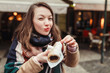 © EdNurg - A woman with an appetite eats a traditional Czech sweet pastry called Trdelnik or Trdlo in Prague street