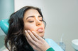 © DenisProduction.com - Young woman having toothache. Sad lady at the dentist. Gum disease symptom.