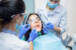 © DenisProduction.com - Two dental doctors and patient. Procedure at the dentist office.