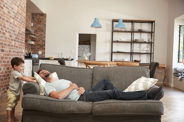 Wall Mural - Father And Son Having Fun Playing On Sofa Together