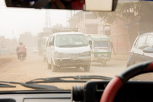 Traffic Rushes Through An Extremely Dusty And Polluted I Street In Kathmandu, Nepal. Shot From The Inside Of A Small Taxi Car.