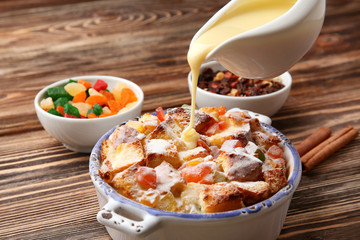 Canvas Print - Pouring custard on freshly baked bread pudding in casserole dish