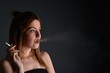 © muro - young woman with cigarette, smoking concept on black background