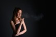 © muro - young woman with cigarette, smoking concept on black background