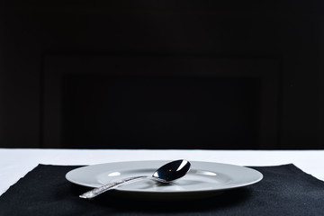 white plate with knife and fork on a black napkin