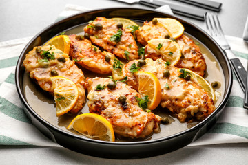 Delicious chicken piccata with sauce and lemon on plate