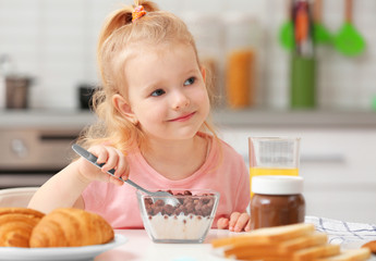 Poster - Cute little girl having breakfast at home