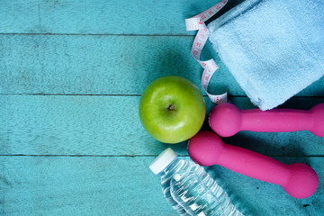 Top view of fitness equipment and nutrition food on blue wooden background. Fitness concept.