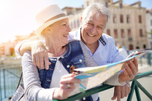 Senior Couple Of Tourists Looking At City Map