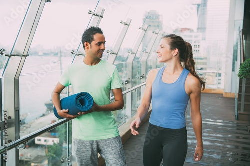 Fotografía Smiling young man and woman talking on gym balcony