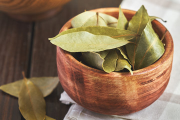 dry bay leaves (laurus nobilis) in wooden bowl