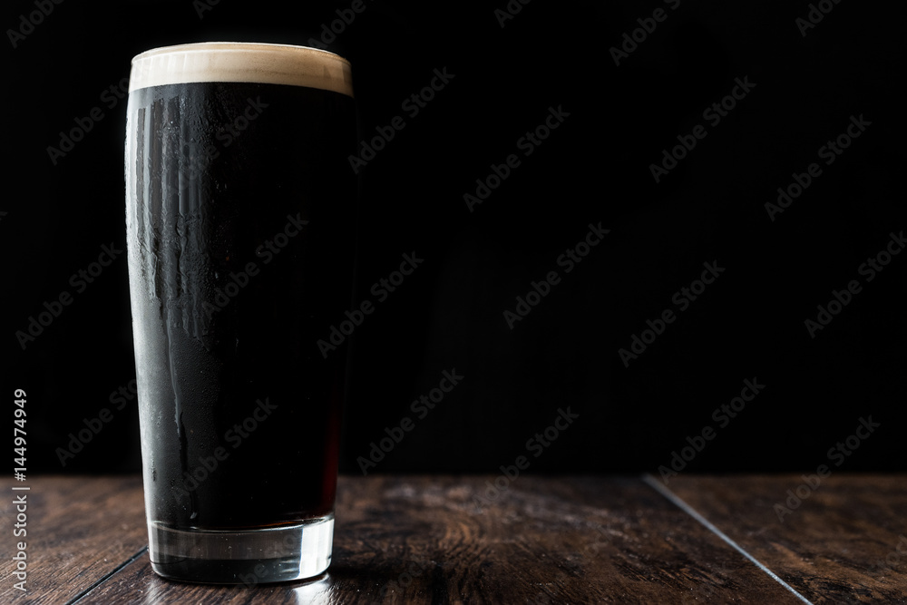 Dark beer on wooden surface. copy space. - obrazy, fototapety, plakaty 