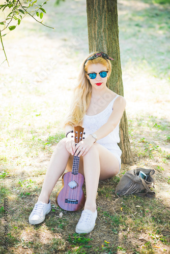 Fotografía Young beautiful woman outdoor city park playing ukulele - musician, composer, bu