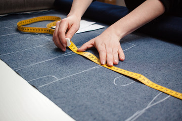 seamstress working with blue jeans fabric