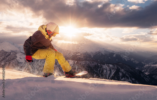Cuadros en Lienzo snowboarder is riding on the sunset