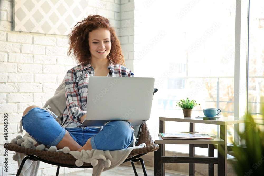 Beautiful young woman using laptop at home - obrazy, fototapety, plakaty 