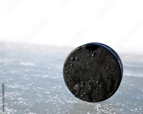 Fototapeta na szkło Hockey puck on a ice rink.
